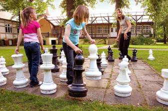 Vorschaubild Frau spielt mit zwei Mädchen im alten Kurpark von Bad Wilsnack hinter dem Kurmittelhaus Schach auf dem Rasen