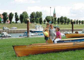 Vorschaubild Junge mit Ball in der Hand mit Mädchen rund um die Ruderboote des Elmshorner RC, welche am Nedwighafen in Wittenberge rasten, wo mehrere Motorboote und die Wasserschutzpolizei an den Kaimauern der Elbe festgemacht sind