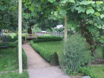 Vorschaubild Garten mit Torbogen, mehreren Sitzgelgenheiten, Blumentöpfen und Gewächshaus sind im Harmonie im Garten in Perleberg zu finden