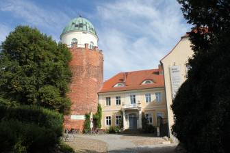 Vorschaubild historische Burg Lenzen mit Eingang zum Hotel und Restaurant sowie Burgturm, in dem sich heute eine Ausstellung des BUND und ein Museum befindet