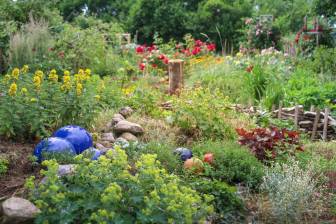 Vorschaubild Naturnaher Garten mit dekorativen Kugeln und Steinen sowie Weiderich, Frauenmantel, Gipskraut, Kräutern, Gräsern und Rosen