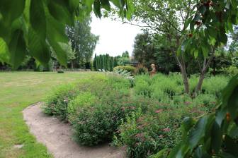 Vorschaubild Zum Tag der Offenen Gärten öffnet der Martinshof mit Wiese und Liegen und einer üppigen Büschen 