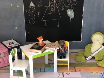 Vorschaubild Spielzimmer mit Tafel, Kuschentieren, Sitzecke und Puzzlen auf Spielteppich im Hotel zur Übernachtung La Maison Bett & Bike in der Prignitz in Brandenburg